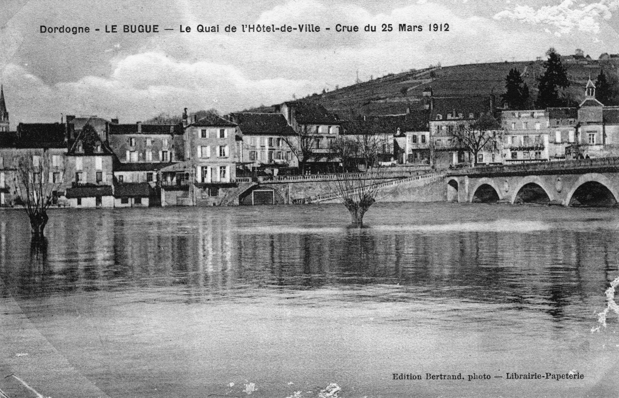 Dordogne – LE BUGUE – Le Quai de l’Hôtel de ville – Crue de la Vézère 25 mars 1912
Postcard – Edition Bertrand, photo – Librairie Papeterie